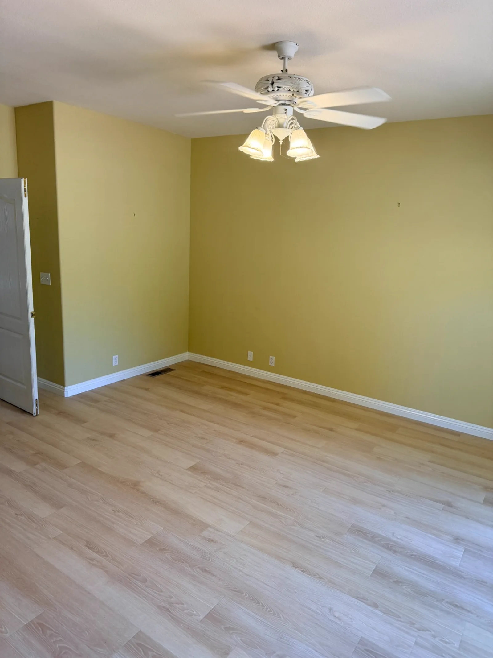 Freshly installed light wood-look flooring in a bedroom